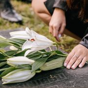 Kinsey Investigations Wrongful Death Cases - The hands of an unseen person place flours on a grave marker.