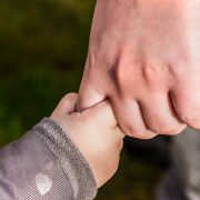 KinseyInvestigations.com Family Law Investigations - A small child's hand clasps an adult's finger.