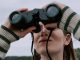 KinseyInvestigations.com Surveillance Investigations - A woman looks through a pair of binoculars