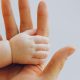 KinseyInvestigations.com Child Custody Investigator - A baby's hand holds a parent's finger.