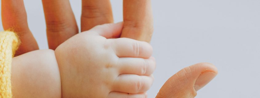 KinseyInvestigations.com Child Custody Investigator - A baby's hand holds a parent's finger.