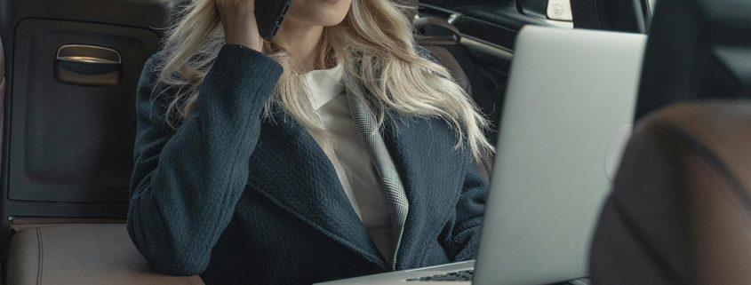 KinseyInvestigations.com What Does a Private Investigator do? - A woman with a laptop speaks on her cell phone while riding in a car.