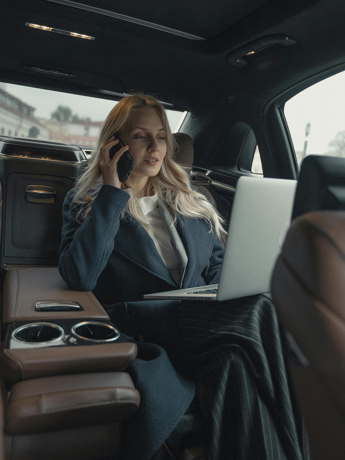 KinseyInvestigations.com What Does a Private Investigator do? - A woman with a laptop speaks on her cell phone while riding in a car.