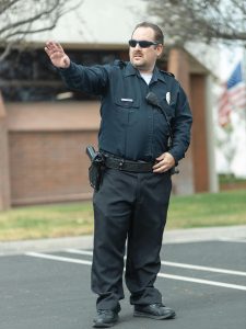 KinseyInvestigations.com Corporate Security Investigations - A uniformed security guard directs traffic.