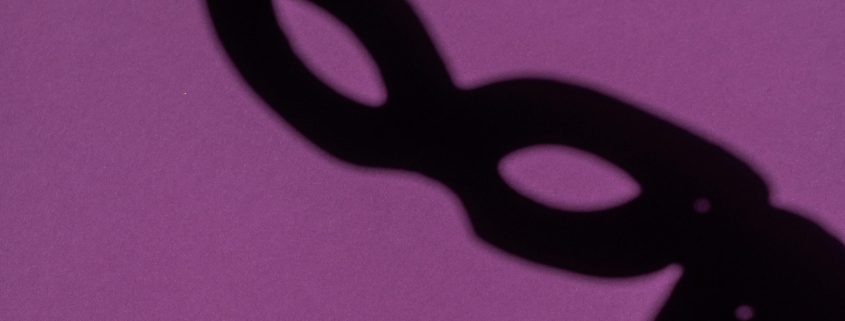 KinseyInvestigations.com Background Check Screenings - The shadow of a theatrical face mask is cast on a purple background.