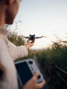 KinseyInvestigations.com Detectives Using Drones - An operator prepares to launch a drone over a field.