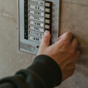 KinseyInvestigations.com Process Service - A hand reaches for a doorbell button.