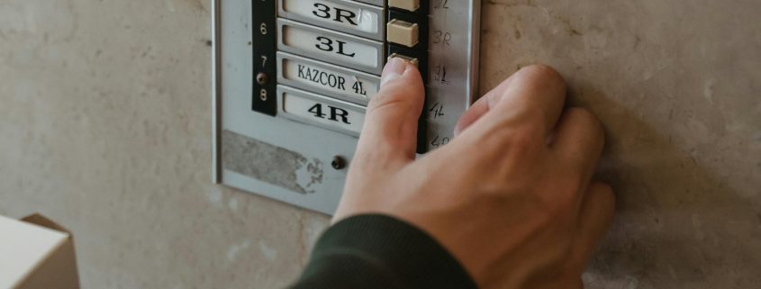 KinseyInvestigations.com Process Service - A hand reaches for a doorbell button.