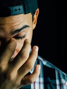 KinseyInvestigations.com How much does a cheating investigator cost - A man holds his hand up to his face.