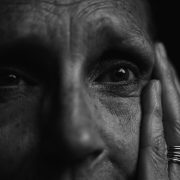 KinseyInvestigations.com Elder Abuse - An elderly person holds their palm to the side of their face.