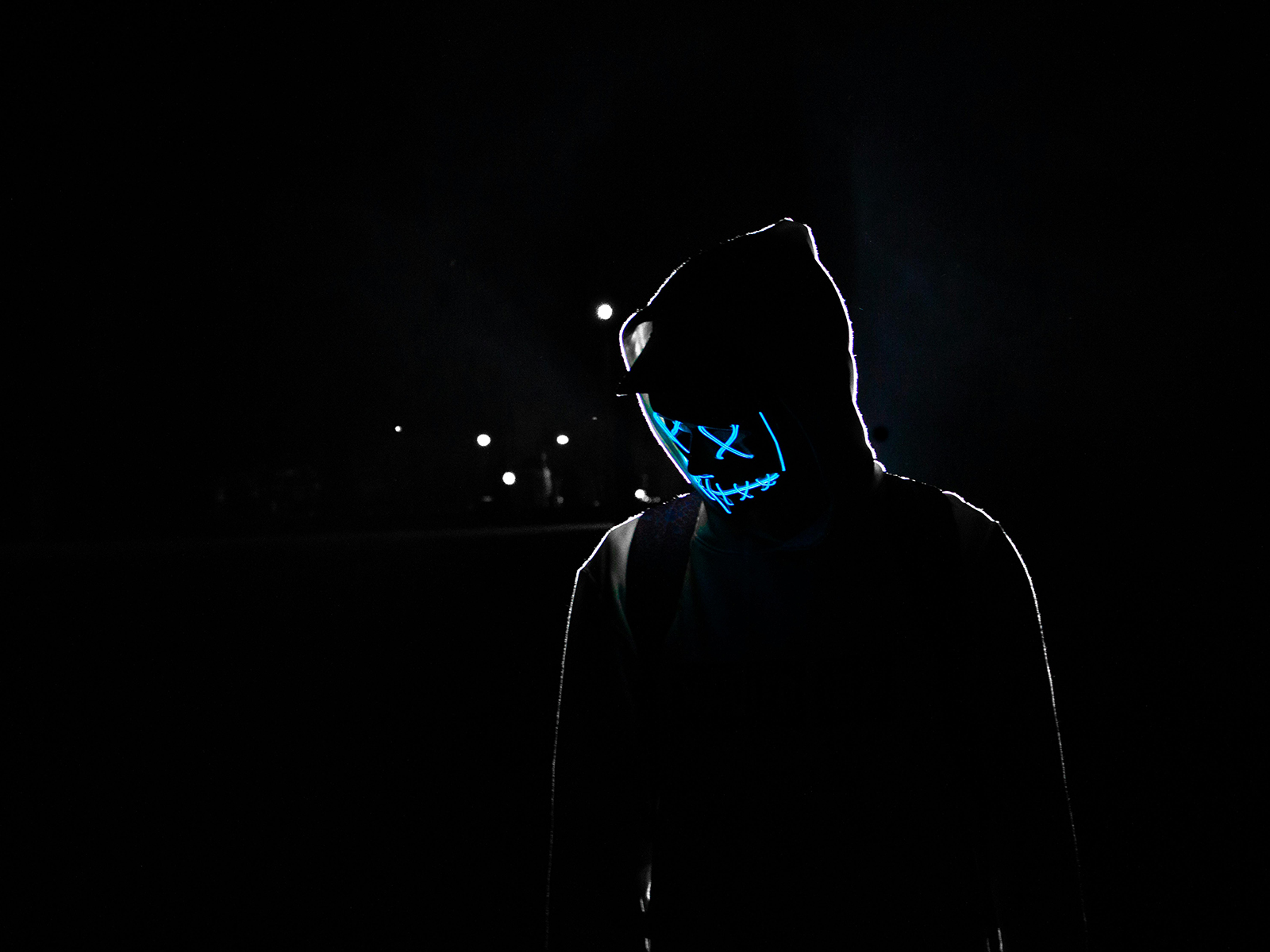 KinseyInvestigations.com Catfishing Detective - A person dressed in black wears a glowing mask.