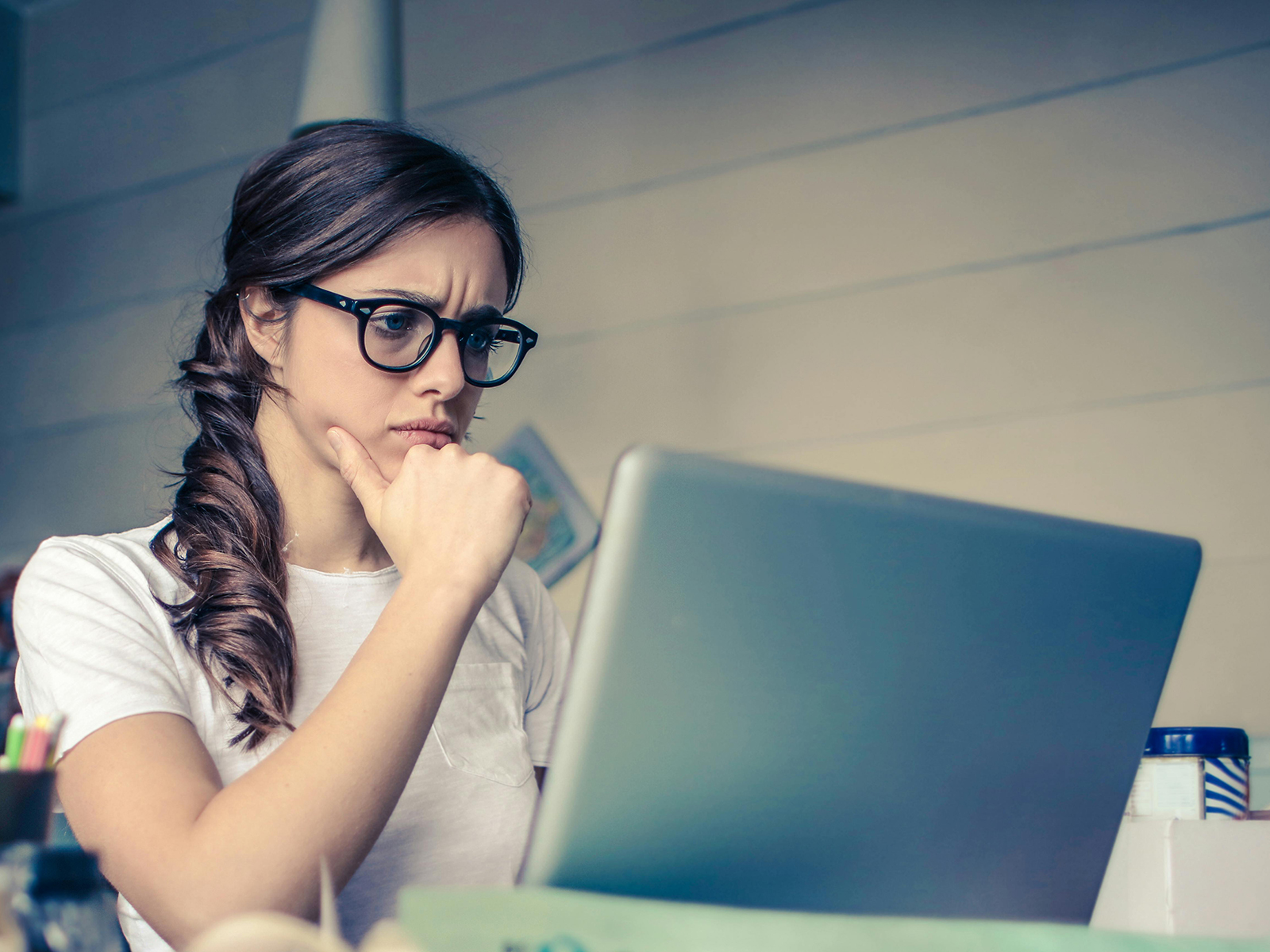 KinseyInvestigations.com How to Choose a Private Investigator - A woman appears concerned as she focuses on her laptop screen.