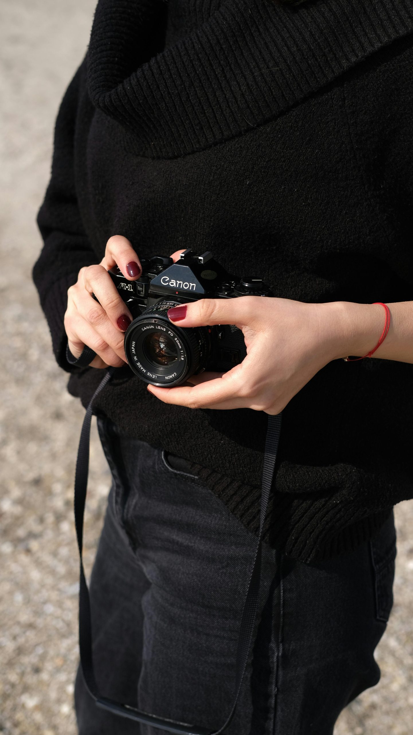 View of female detective from neck to waist holding a camera in her hands - Visit KinseyInvestigations.com.
