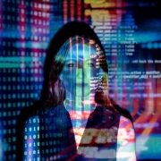 Woman standing in front of colorful projection of computer coding - Consult Kinsey Investigations.