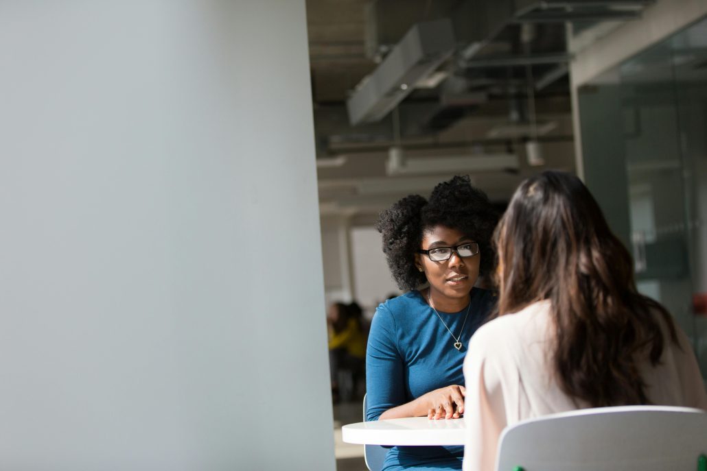 Two women conversing in a public place - Contact Kinsey Investigations.