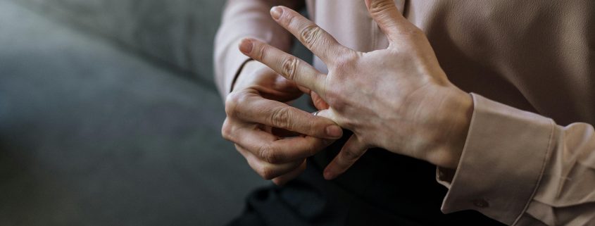 A man beneath the shoulders removing his wedding ring - Visit KinseyInvestigations.com.