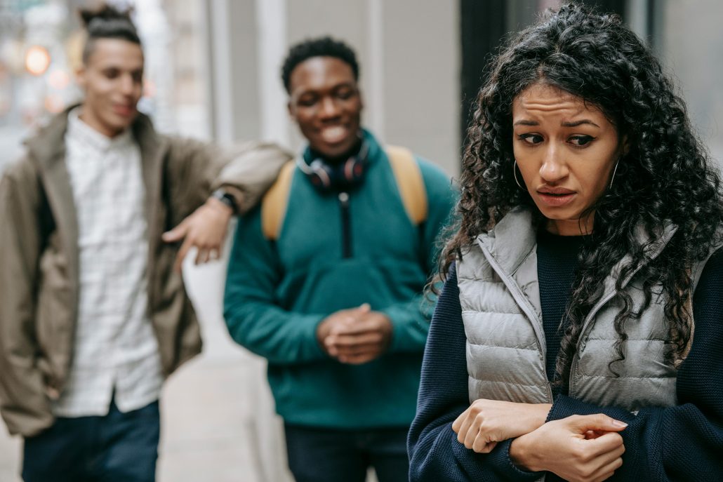 A woman looks uncomfortable as she's followed by two men - Consult Kinsey Investigations. 