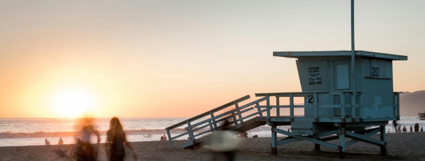 A lifeguard tower and people on the shore at Long Beach - Contact Kinsey Investigations.