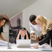 A group of people surrounding a woman at a computer who looks overwhelmed - Consult Kinsey Investigations.