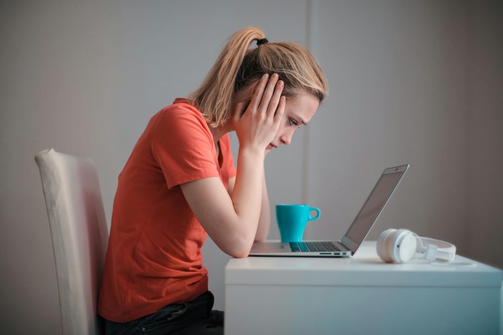 Concerned woman looking at laptop screen - Consult Kinsey Investigations. 