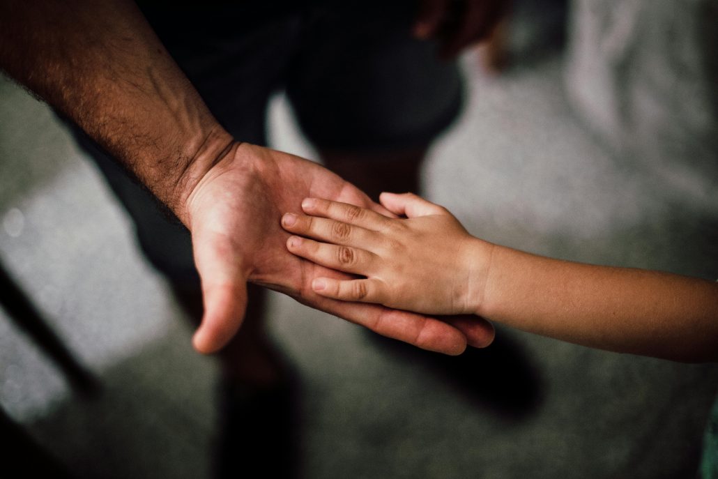 Child's hand in parent's - Consult Kinsey Investigations. 